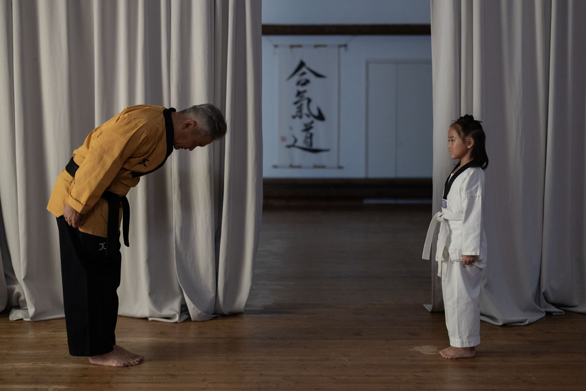 Instructor bowing to a young student, a gesture of mutual respect
