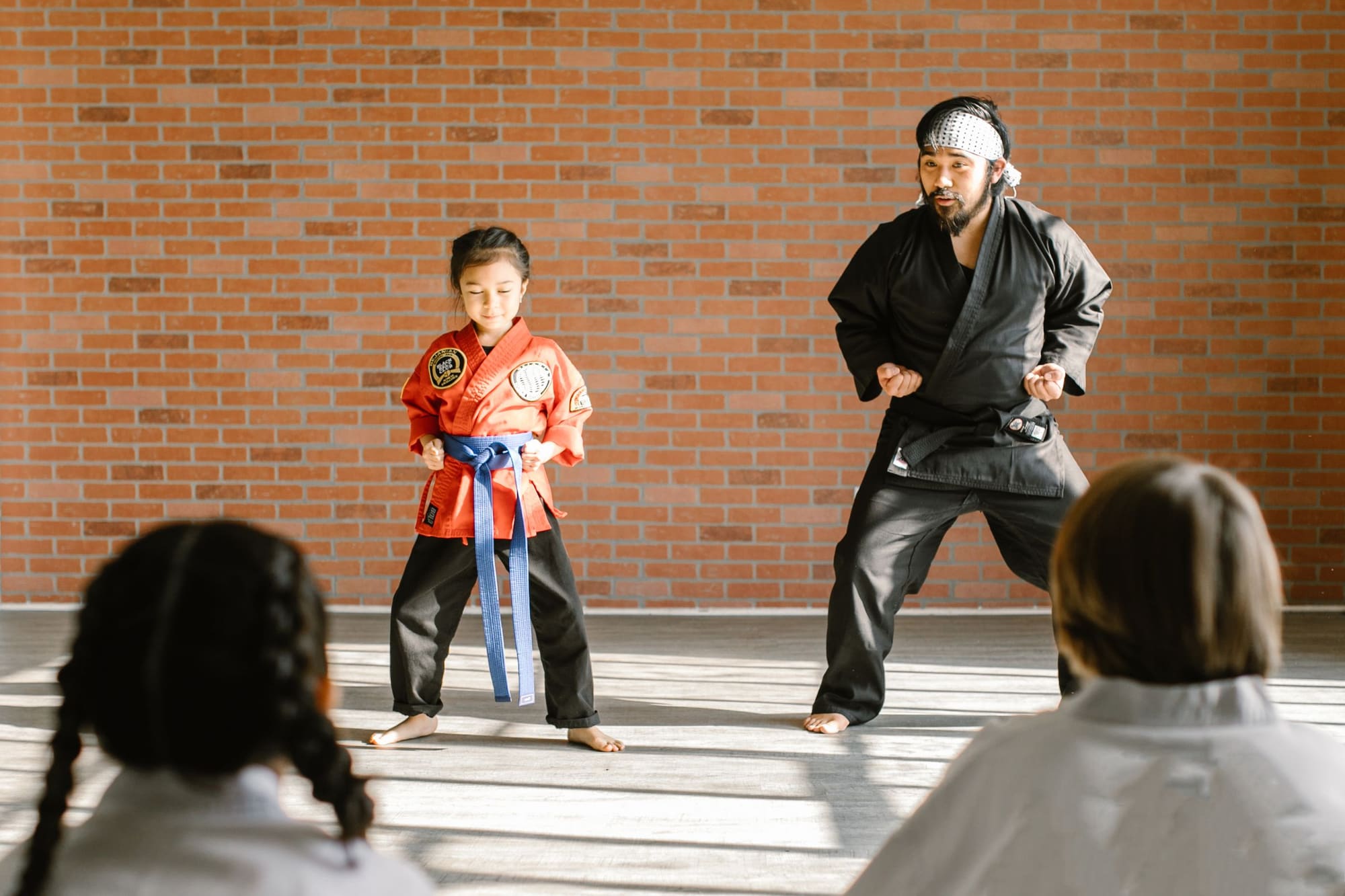 Instructor guiding a young student through technique in the dojang