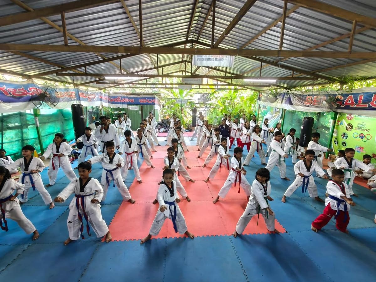 Group of children learning martial arts in a sunlit training hall