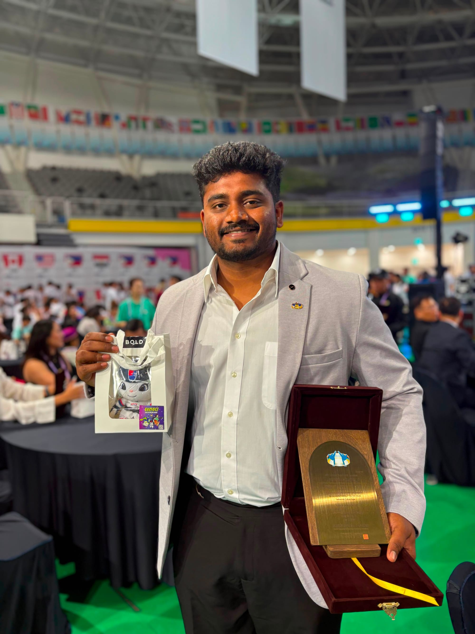 Gautham, Head of Training at Kwans Taekwondo Academy, receiving a recognition award at an international Taekwondo expo