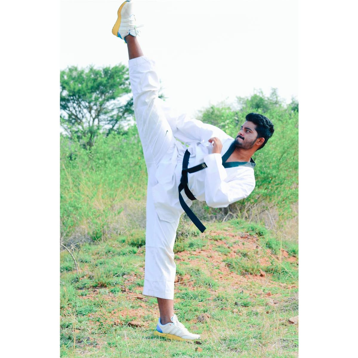 Martial artist executing a high kick in a training studio