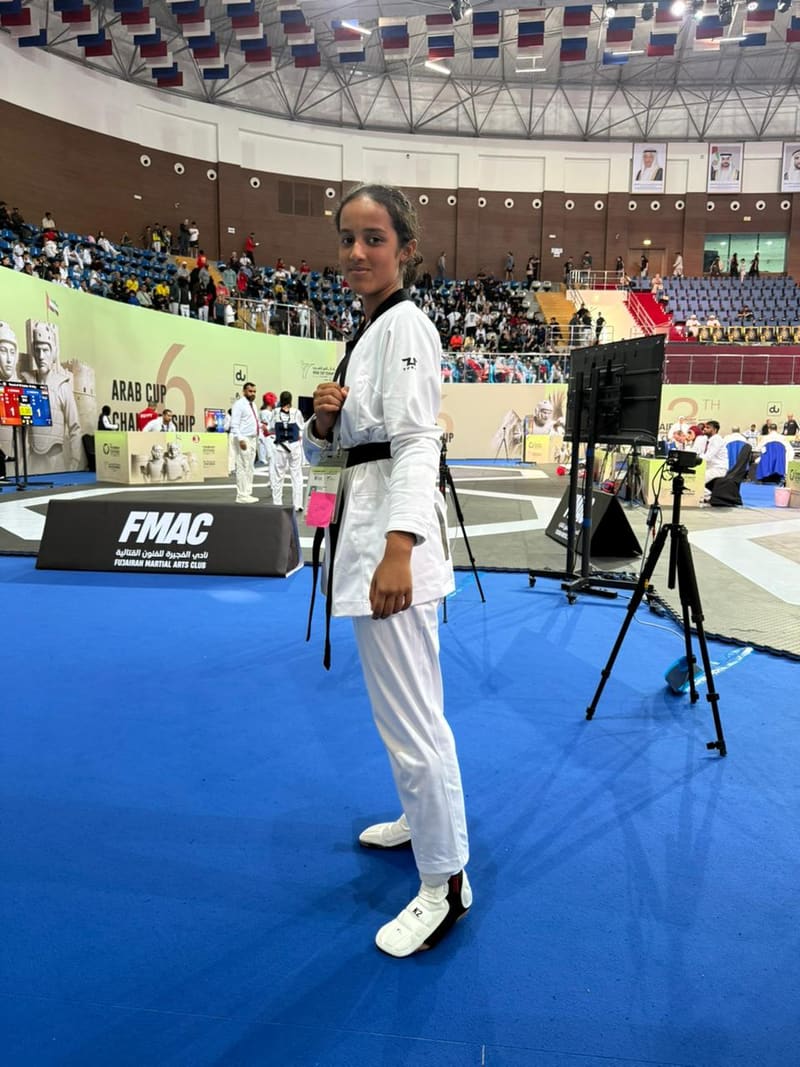 Young martial artist holding a disciplined poomsae stance outdoors